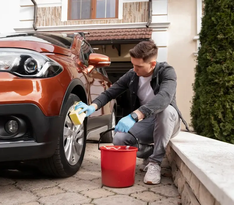Lavage auto à domicile Messia-sur-Sorne : professionnel intervenant sur un véhicule